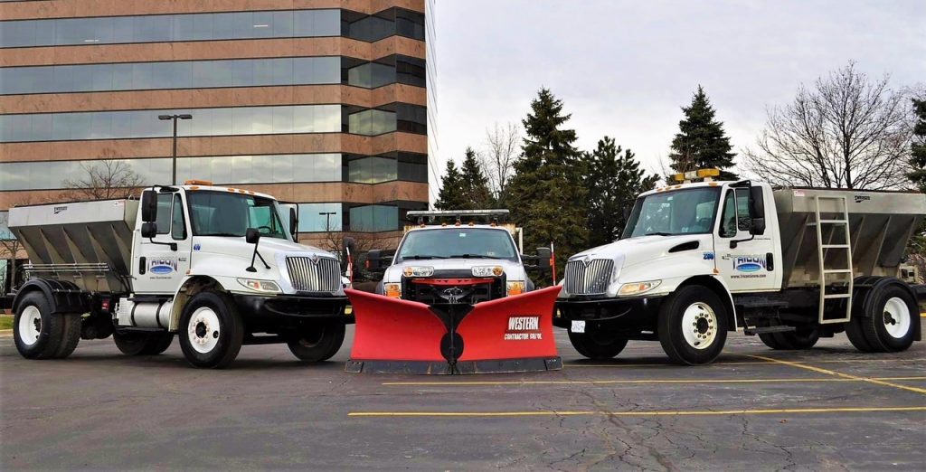 Three trucks standing together in a parking lot